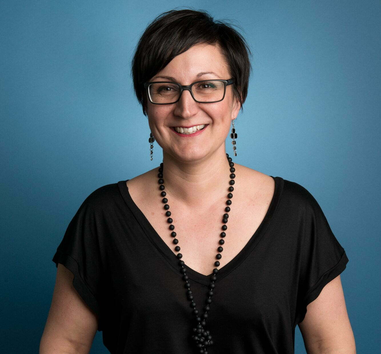 Headshot of Maria Naveira Sund, on a blue background.