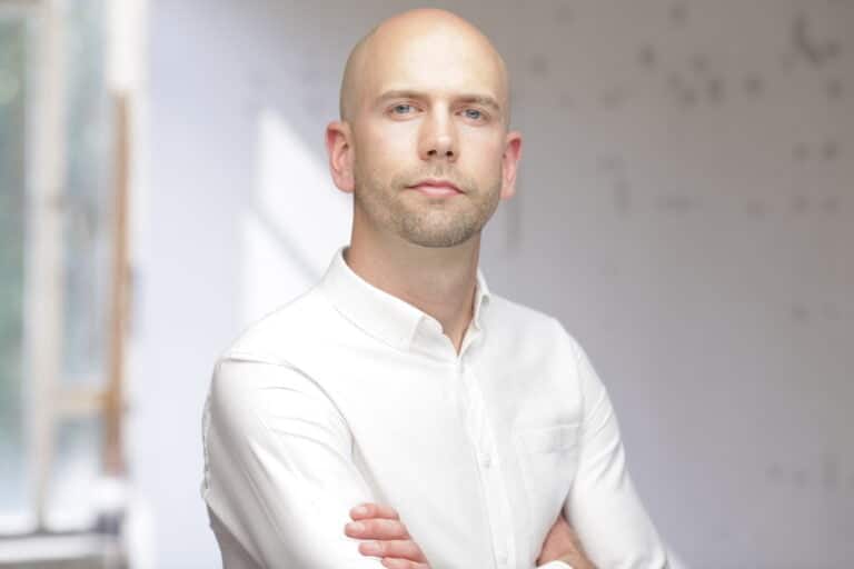 A headshot of Simon Noy, looking into the camera with arms folded.