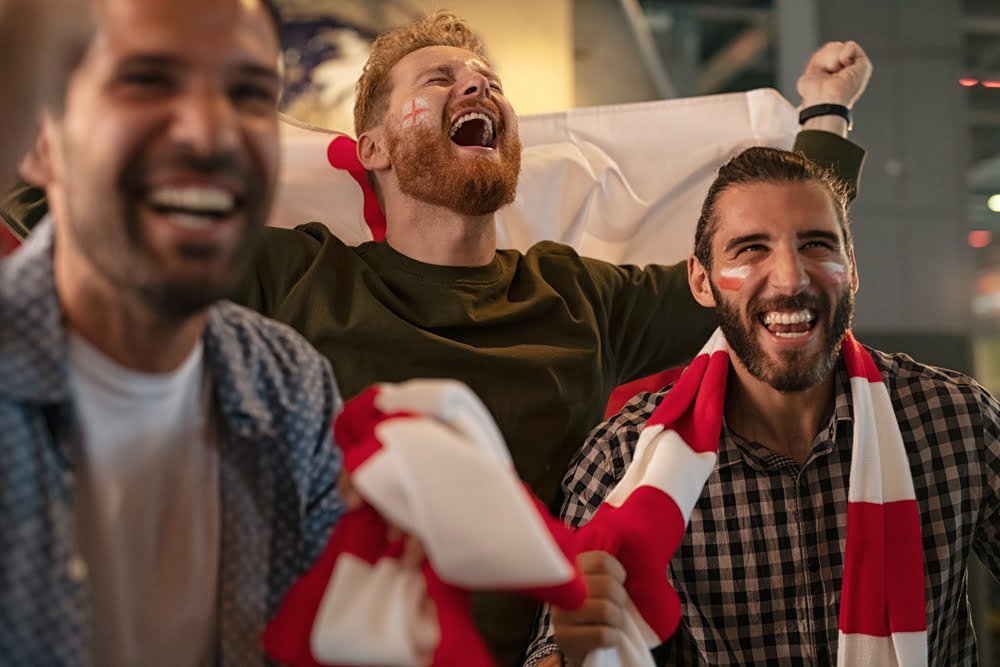Three,Friends,Cheering,For,England,Sports,Team.,Football,Fans,Wearing