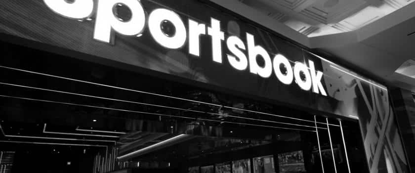 A black and white picture of a Sportsbook location with televisions playing sports.